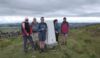 The walkers gather round the trig point overlooking Buxton